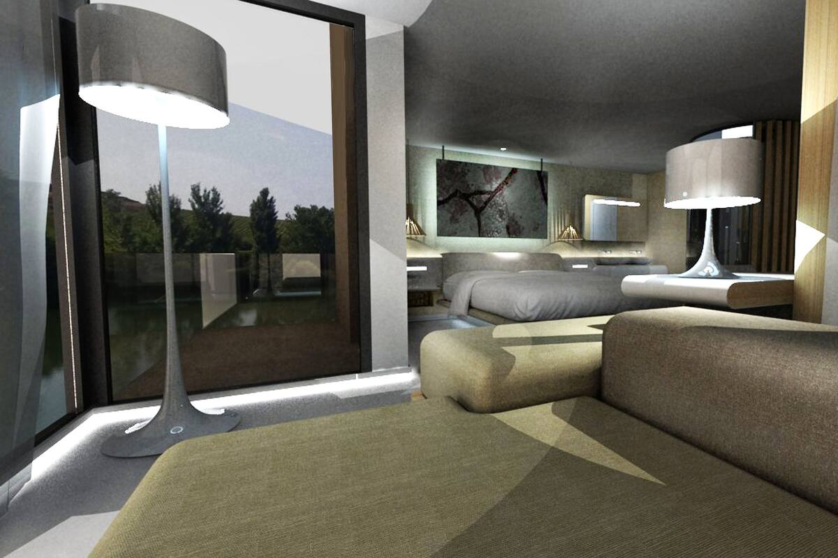 A modern hotel room with a large bed, a sofa, a desk, and a large window offering a view of the outdoors.