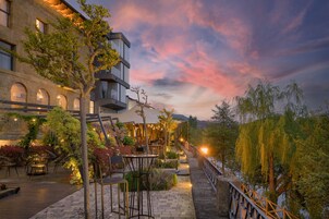 Un patio con asientos al aire libre, un edificio de piedra y una vista del cielo.