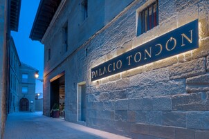 Un edificio de piedra con un letrero que dice "PALACIO TONDÓN".