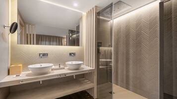 Un baño moderno con dos lavamanos, un espejo grande y una cabina de ducha de vidrio.