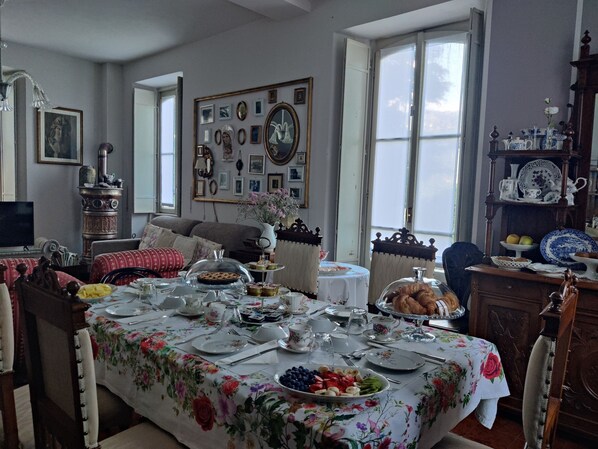 A dining room with a table set for a meal, surrounded by chairs. - Villa Laura (Lierna)