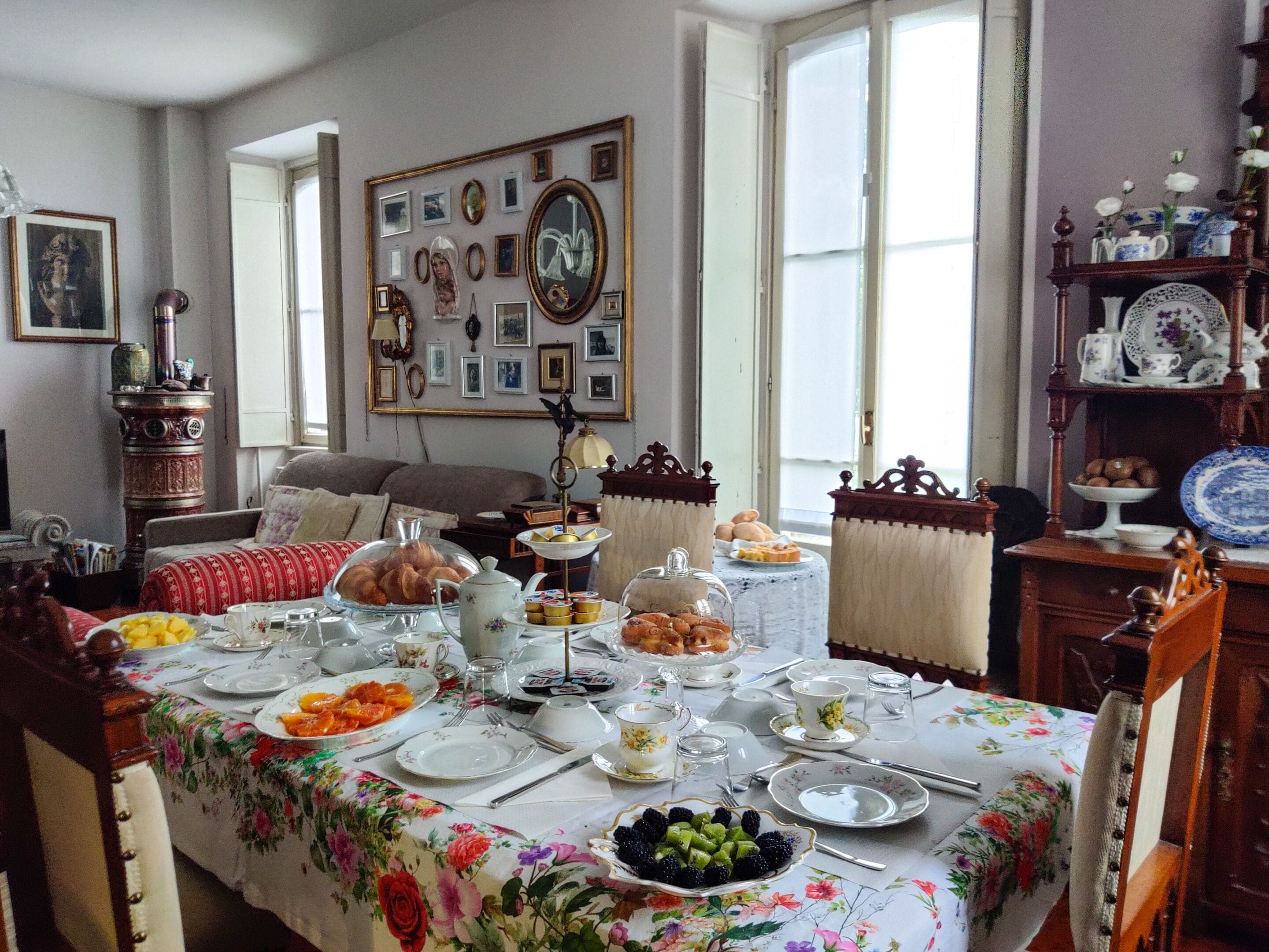 A dining area with a table set for a meal, surrounded by chairs and a sofa.