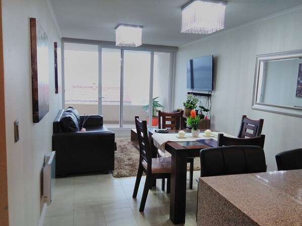 A dining area with a table, chairs, and a TV mounted on the wall.