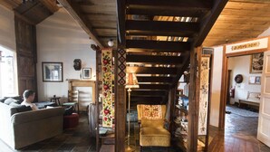 A cozy living room with a fireplace, a sofa, and a chair. - Raven's Bed and Breakfast (Reykjanesbær)