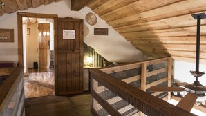 A wooden interior with a high ceiling, a wooden staircase, and a wooden railing. - Raven's Bed and Breakfast (Reykjanesbær)
