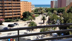 Un hôtel à plusieurs étages doté de balcons, d’un parking avec des voitures et offrant une vue sur la mer.