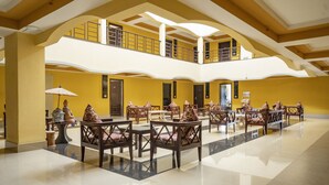 Um hall amplo com várias áreas de estar, varanda no segundo andar e design arquitetônico moderno.