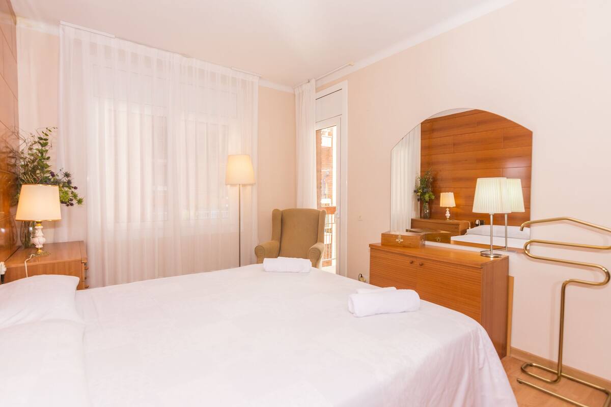 Ein Hotelzimmer mit einem großen Bett, einem Holzschrank, einem Stuhl und einem Spiegel.