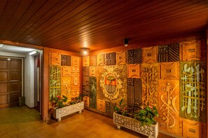 A hallway with intricate wall carvings and two ornate planters with plants. - HomeHolidaysRentals Apartamento Amaral - Costa Barcelona (Pineda de Mar)