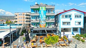 A hotel with a colorful mural, outdoor seating, and a pool. - Yasemin Hotel (Fethiye)