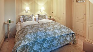 Ein Schlafzimmer mit einem großen Bett, zwei Nachttischlampen, einem Nachttisch und einem Kleiderschrank.