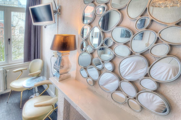Un baño con una pared de espejos, un televisor y una lámpara.