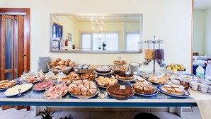 Una mesa de buffet con diversos alimentos y un espejo grande colgando encima.