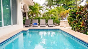 A swimming pool with lounge chairs and palm trees. - Vista del Mar by NAS (Playa del Carmen)