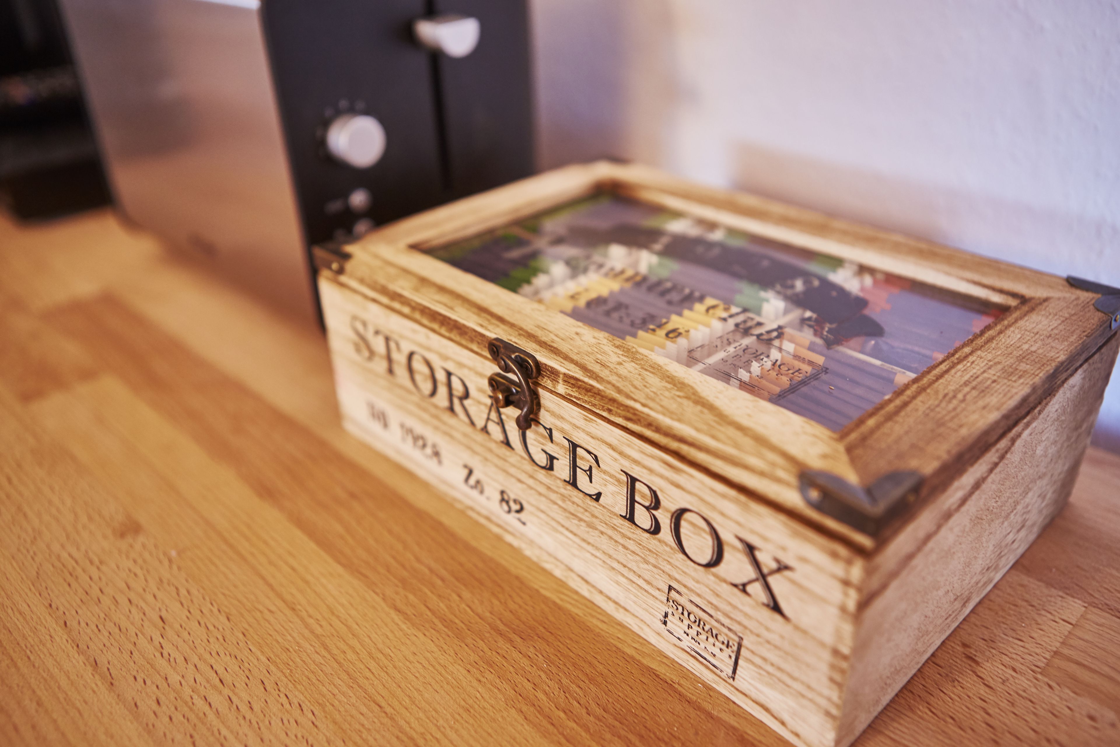 A wooden storage box with a hinged lid and a small latch.