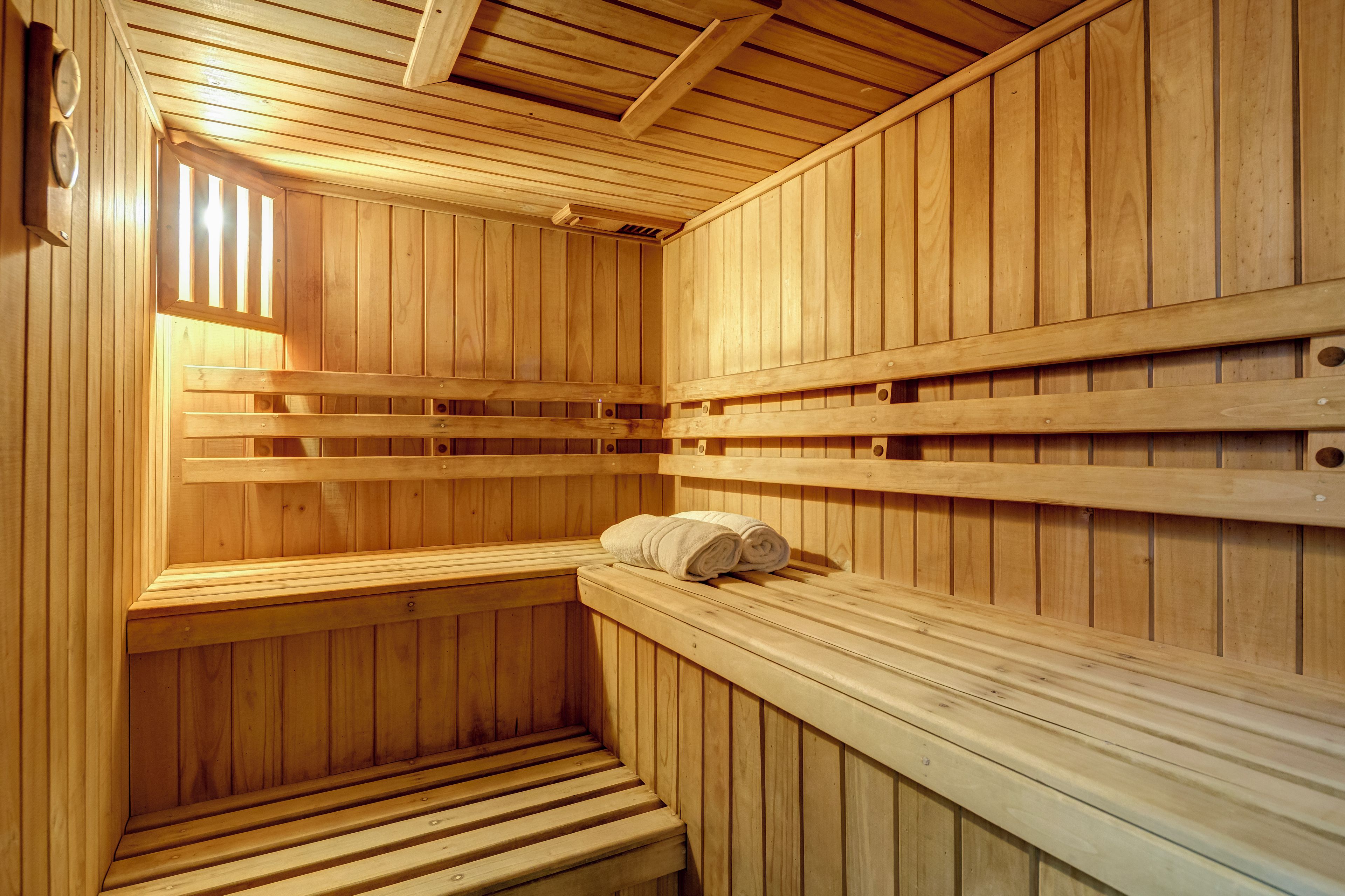 Una sauna con bancos de madera y una toalla sobre uno de ellos.