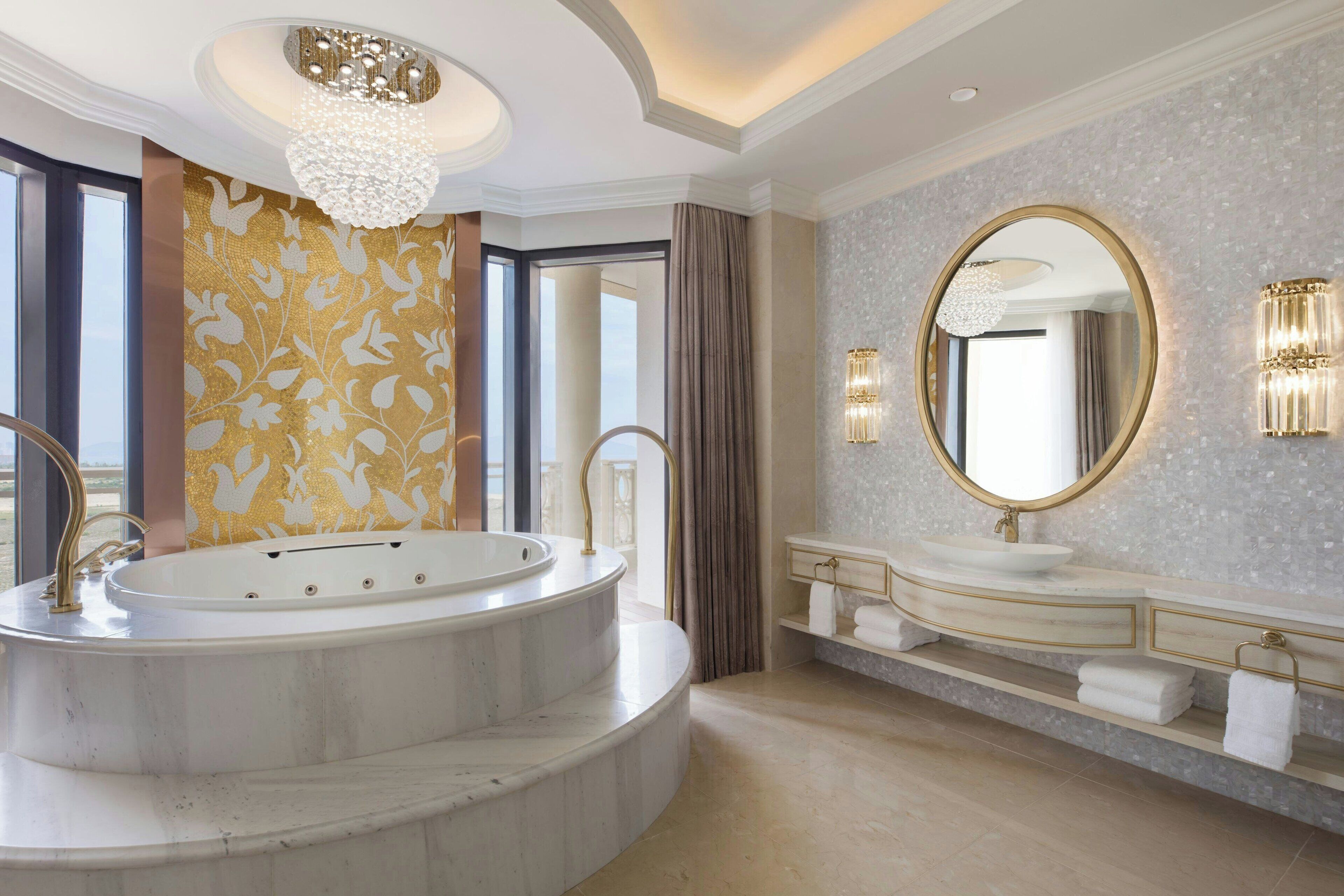 A luxurious bathroom with a freestanding bathtub, a large mirror, and a marble countertop.