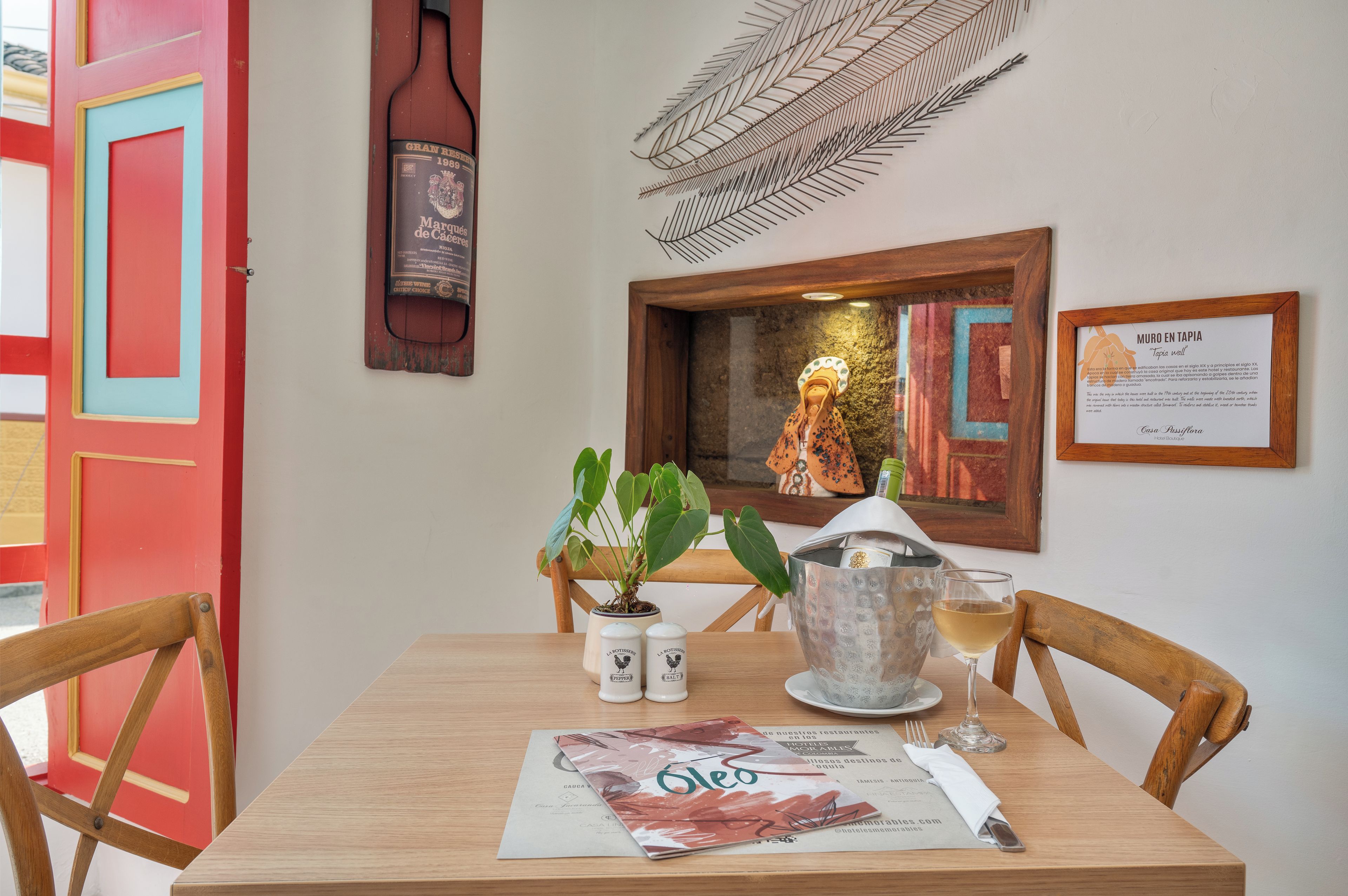 A dining table with a menu, salt and pepper shakers, a glass of wine, and a decorative plant.