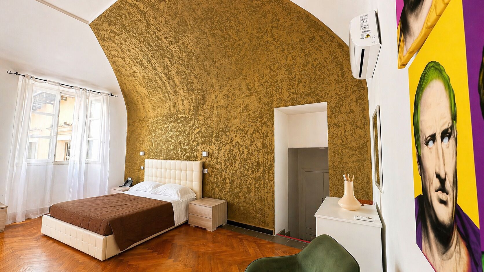 Une chambre à coucher comprenant un lit, une table de chevet, une commode et un climatiseur fixé au mur.