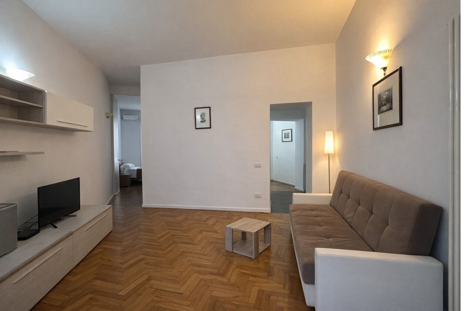 En moderne stue med sofa, TV og sofabord.
