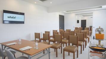 Ein Konferenzraum mit einer großen Leinwand, auf der