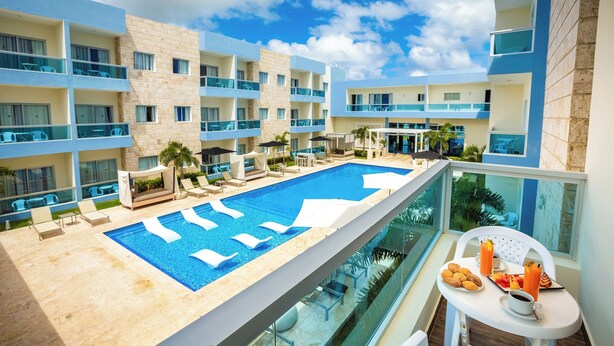A hotel with a rooftop pool, outdoor seating, and a balcony with breakfast. - whala!urban punta cana (Punta Cana)