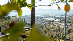 A view from a balcony with a wooden pergola, overlooking a valley with houses and a distant mountain range. - Hotel Belvedere (Sperlonga)