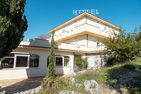 Un edificio de dos pisos con un letrero que dice "HOTEL" sobre la entrada.