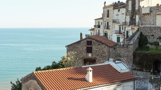 A coastal building with a tiled roof, stone walls, and a view of the sea. - Hotel Belvedere (Sperlonga)