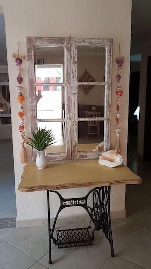 A rustic table with a vintage mirror, decorated with seashells, a potted plant, and a white cushion. - Hotel Casarão Pitangueiras (Guarujá)