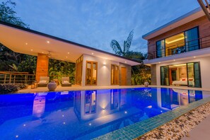 Uma casa moderna com piscina, janelas amplas e varanda.