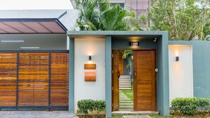 A modern house with a wooden door, a mailbox, and a number plate. - Moin Lakeside Pool Villa ChiangMai (Hang Dong)
