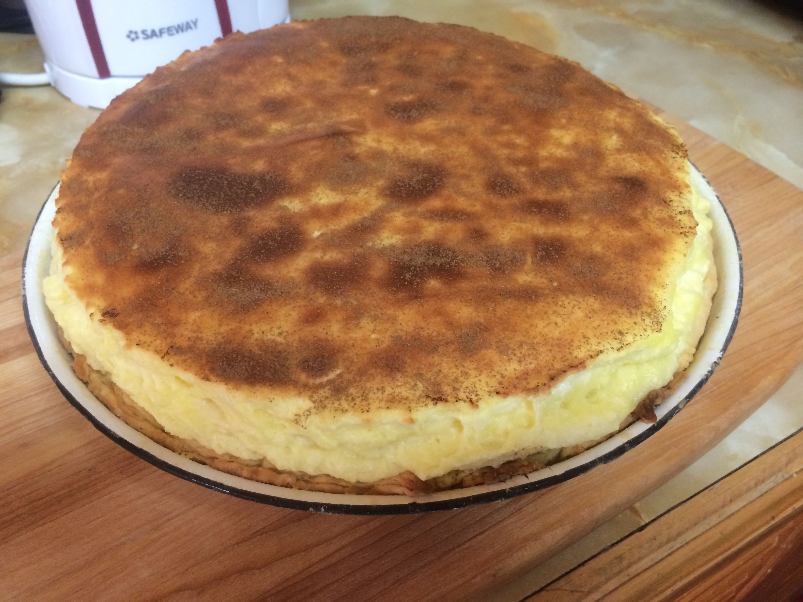 Un pastís de formatge rodó damunt d'una tabla de fusta.