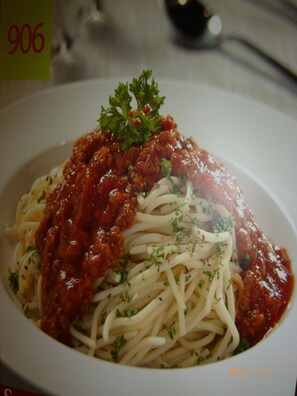 A plate of spaghetti with tomato sauce and parsley garnish. - Go Daily service (Kuala Lumpur)