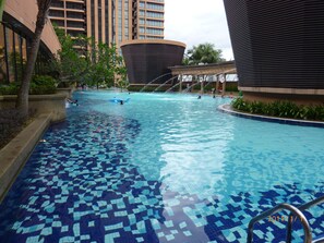 A swimming pool with a tiled floor and a water fountain. - Go Daily service (Kuala Lumpur)