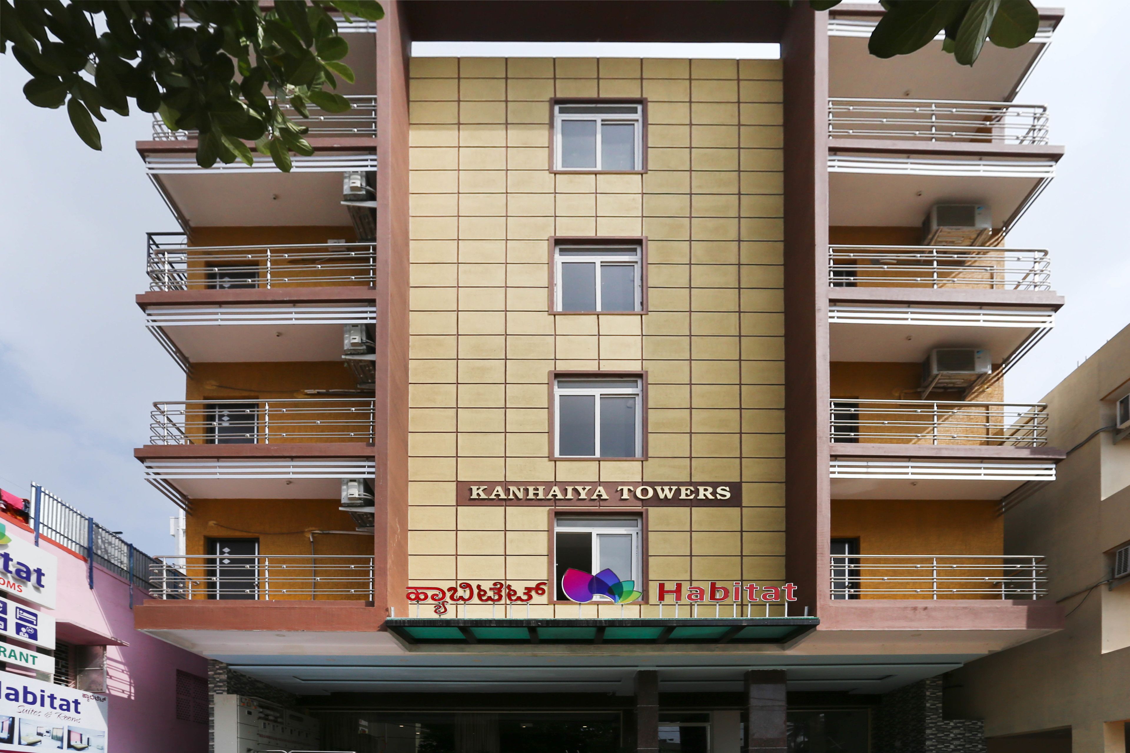A multi-story building with balconies and a sign reading "KANHAIYA TOWERS".