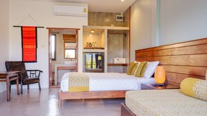 A hotel room with two beds, a desk, a chair, a small kitchenette, and a bathroom. - Le Cocotier Resort (Mae Taeng)