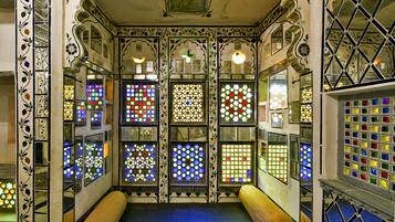 A room with multiple stained glass windows and intricate wall designs.