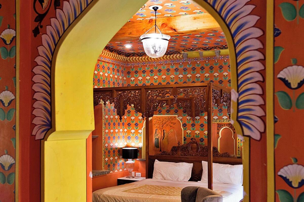 A traditional room with a bed, a chair, and a patterned floor.
