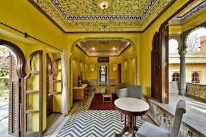 A room with a chevron-patterned floor, a round table, and a sofa.