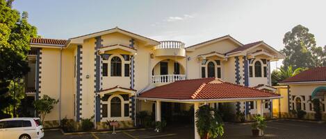 A two-story building with a covered entrance and a parking area.