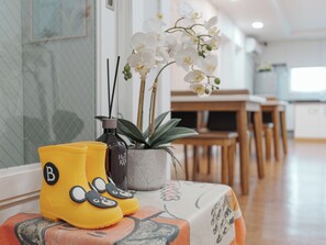 A room with a dining table, chairs, a potted plant, and a bottle of water. - Rainbootsguesthouse (Incheon)