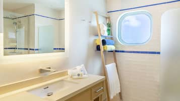 A bathroom with a large mirror, a sink, a towel rack, and a window.