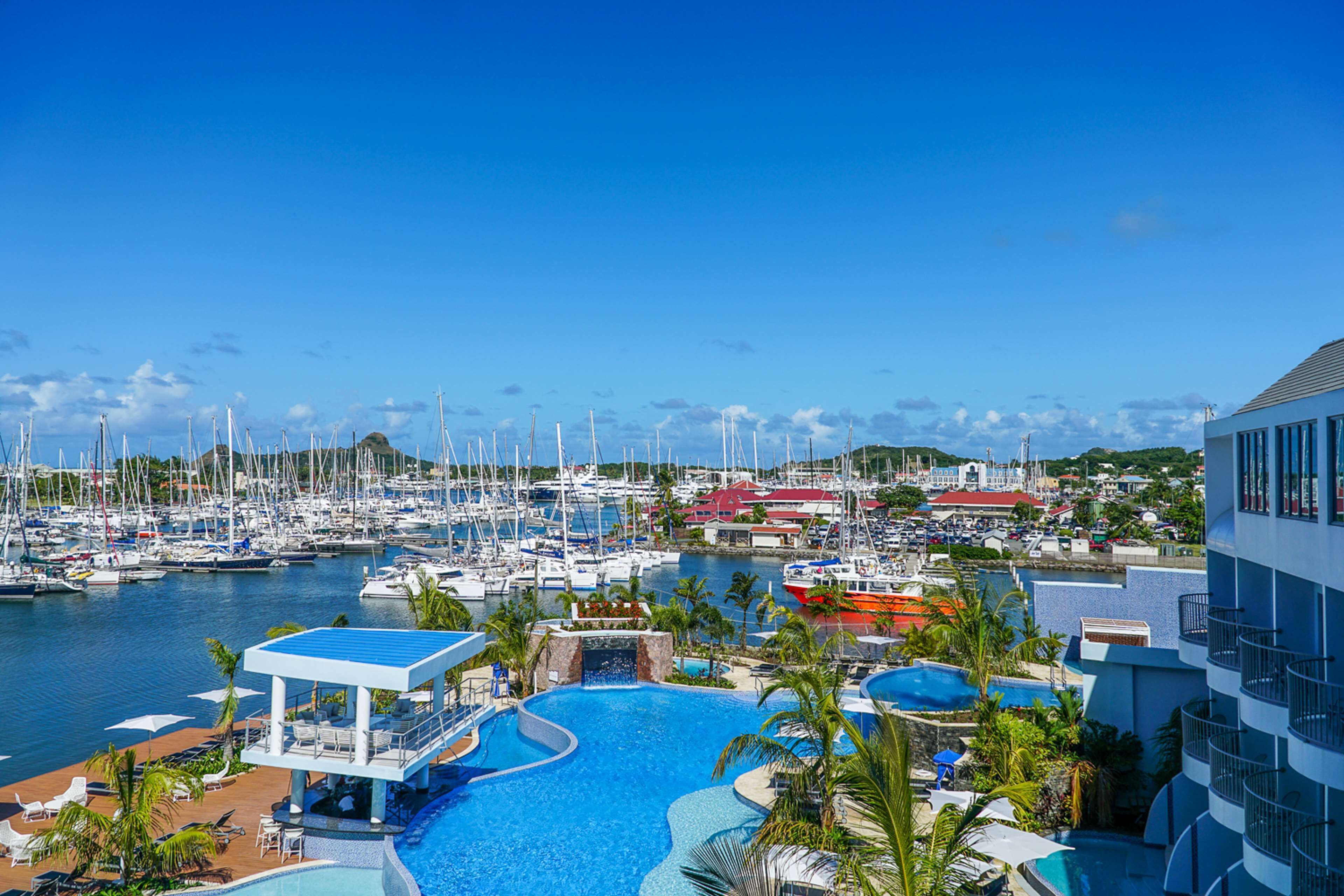 A marina with boats, a swimming pool, and a resort building.
