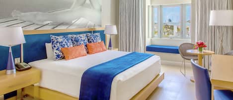 A hotel room with a bed, bedside tables, a desk, a chair, and a window with curtains.