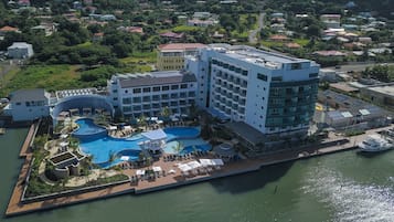 Un resort con varias piscinas, un puerto deportivo y un edificio grande con balcones.