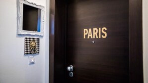 A dark wooden door with "PARIS" in gold lettering. - Deluxe Apartments (Drama)