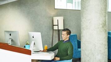 Un espace de bureau moderne où une personne est assise à un bureau et utilise un ordinateur de bureau.