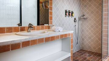 Baño con lavamanos, espejo y ducha.