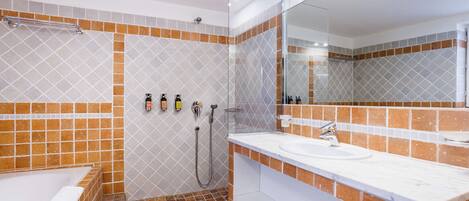 Un baño moderno con bañera, ducha y lavamanos, que cuenta con un salpicadero de azulejos y un espejo grande.